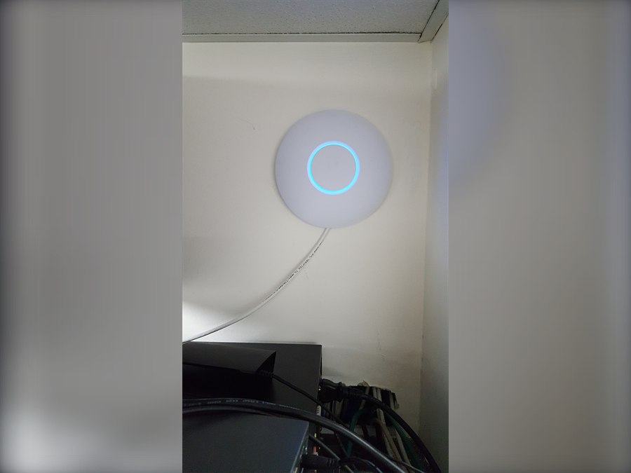 Ceiling-mounted UniFi access point with status LED