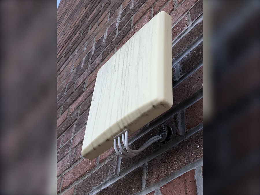 Weatherproof outdoor wireless access point mounted on a wall